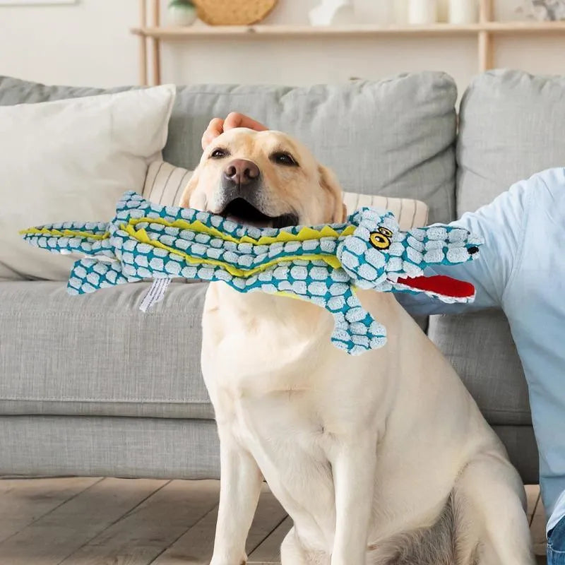 Blue crocodile-shaped plush squeaky dog toy with corduroy fabric on a wooden floor.