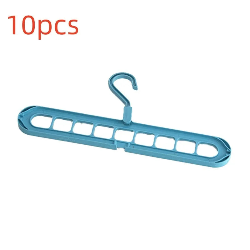 Green plastic nine-hole multifunctional clothes hanger for trousers on a white background.