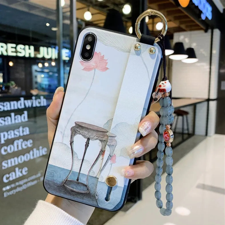 Rose flower design iPhone case with a white wrist strap attached, shown on an iPhone 11.