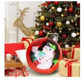 Large red and white striped inflatable Christmas ball ornament hanging on an outdoor tree