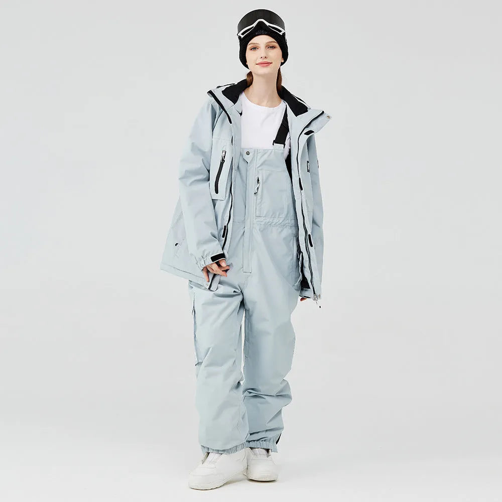 Man and woman modelling a blue and black waterproof ski suit for winter snow sports.