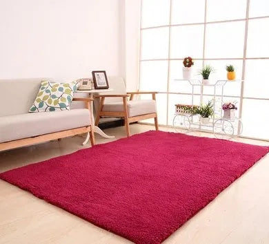 Solid colour plush carpet with soft surface and rectangular shape on hardwood floor