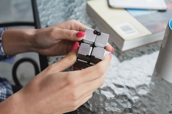 Black zinc alloy infinity cube fidget toy showing eight connected cubes.