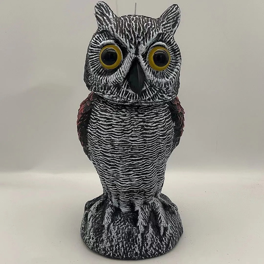 Artificial owl bird deterrent ornament with shaking head design in outdoor garden setting