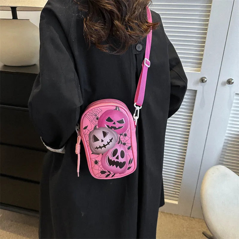 Halloween graffiti print crossbody phone bag with cartoon pumpkins, in multiple colours.