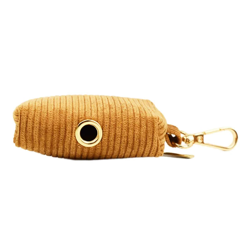 Caramel corduroy pet collar set with ring, rope, bow, vest, and poop bag on a light background