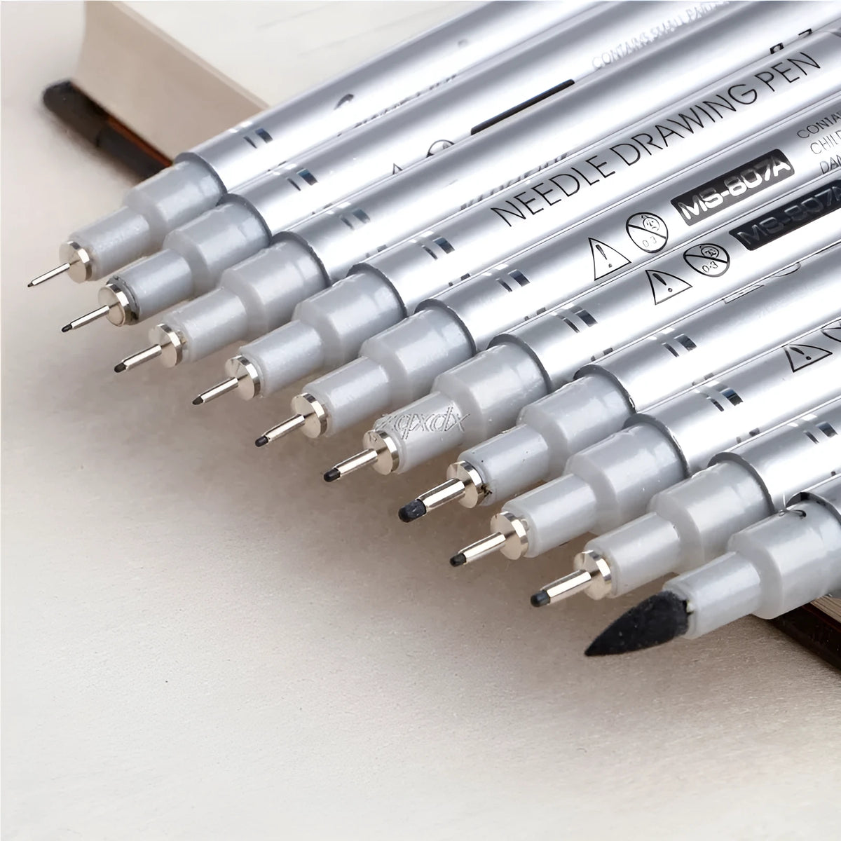 10-pen set of micron needle drawing pens with black pigment ink and assorted colours, showing tip sizes 005 to 20