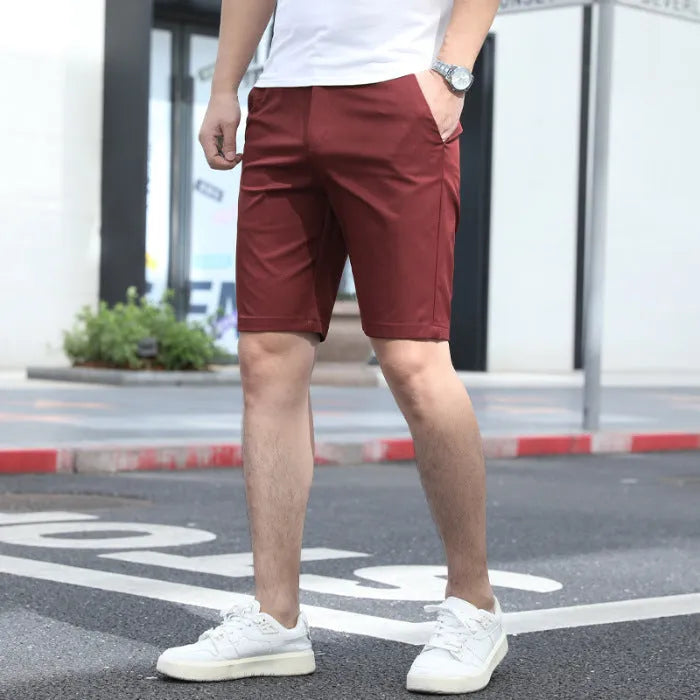 Man wearing loose-fit beige mid-length casual trousers with an elasticated waistband.