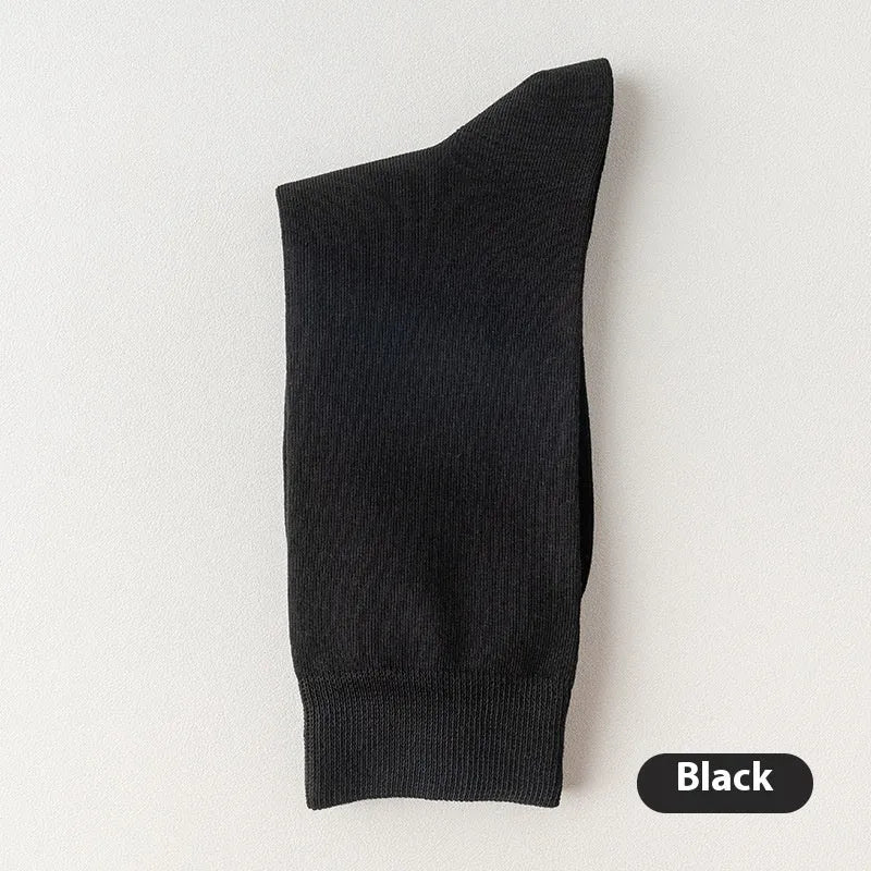 Five pairs of men's solid colour mid-calf socks made from combed cotton, shown in assorted shades.