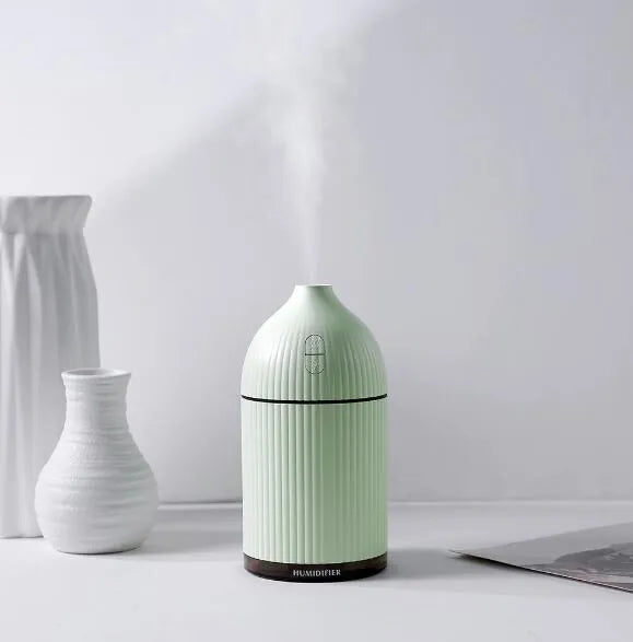 White USB aroma diffuser and humidifier with 300ml tank and LED light on a wooden surface.