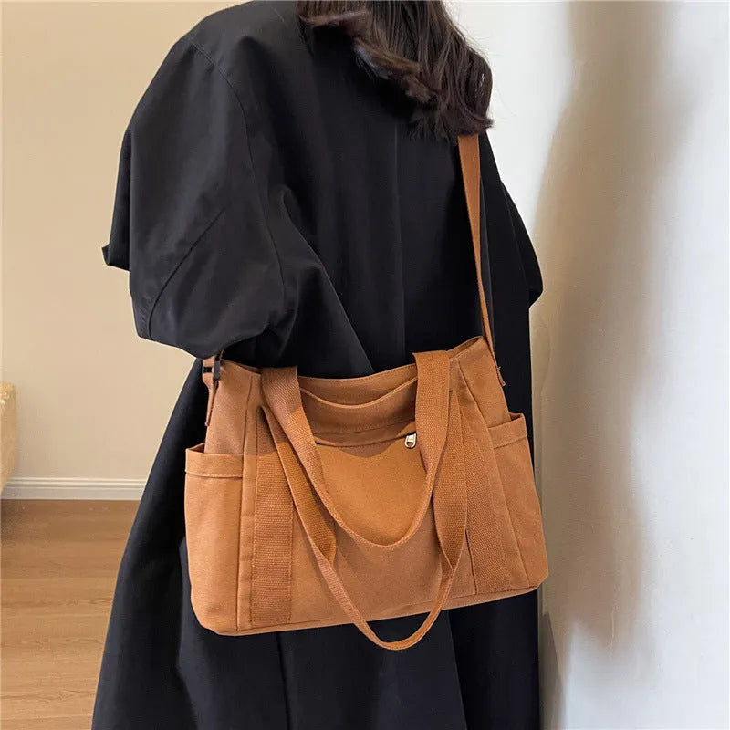 Large capacity polyester canvas shoulder tote bag in a solid colour, showing outer sandwich pocket.