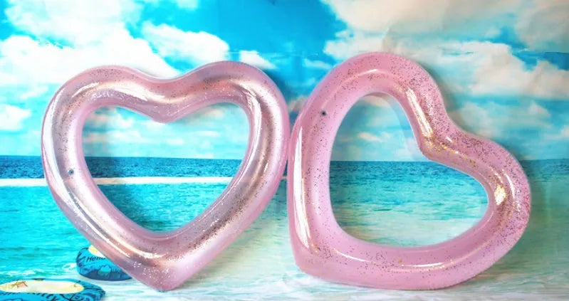 Oversized 120cm heart shaped swim ring in pink floating on water, adult outdoor pool toy
