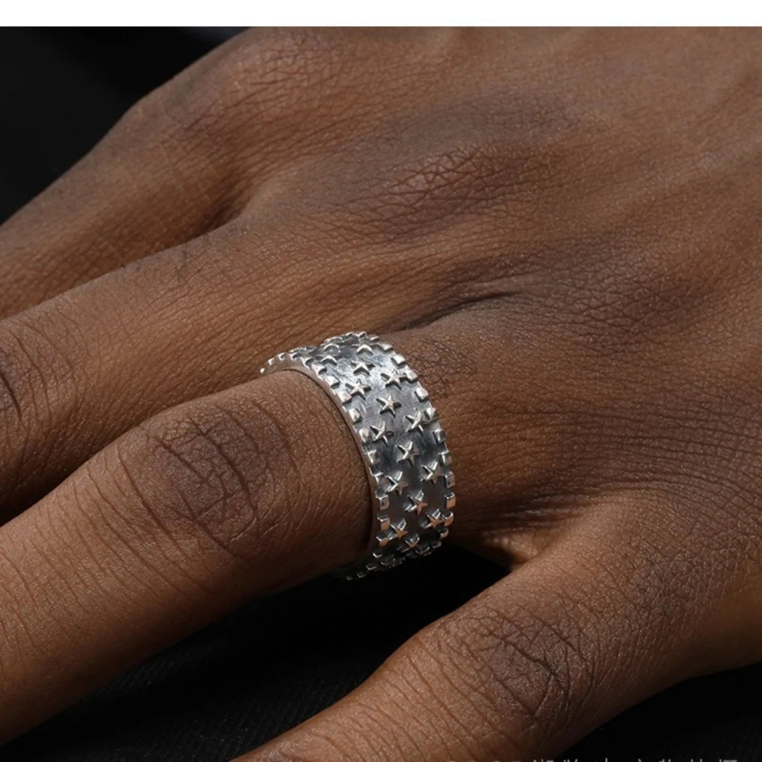 Sterling silver ring with a five-pointed star pattern and an adjustable open band.