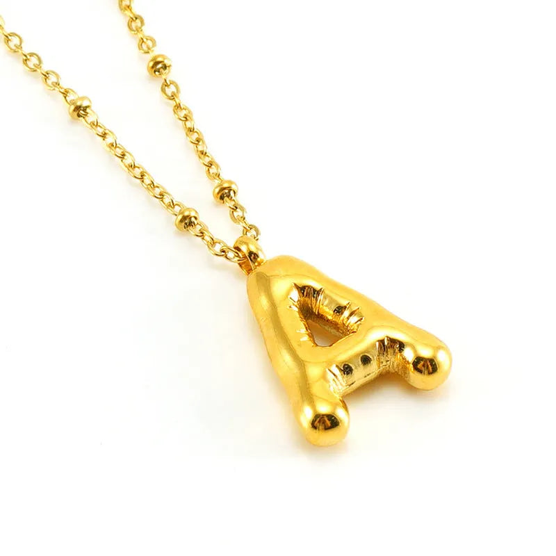 Gold bubble letter N pendant on stainless steel clip beads chain necklace against white background