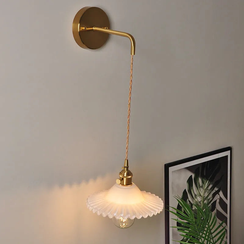 Retro copper Lotus wall lamp with a glass shade in a choice of six colours on a wall.