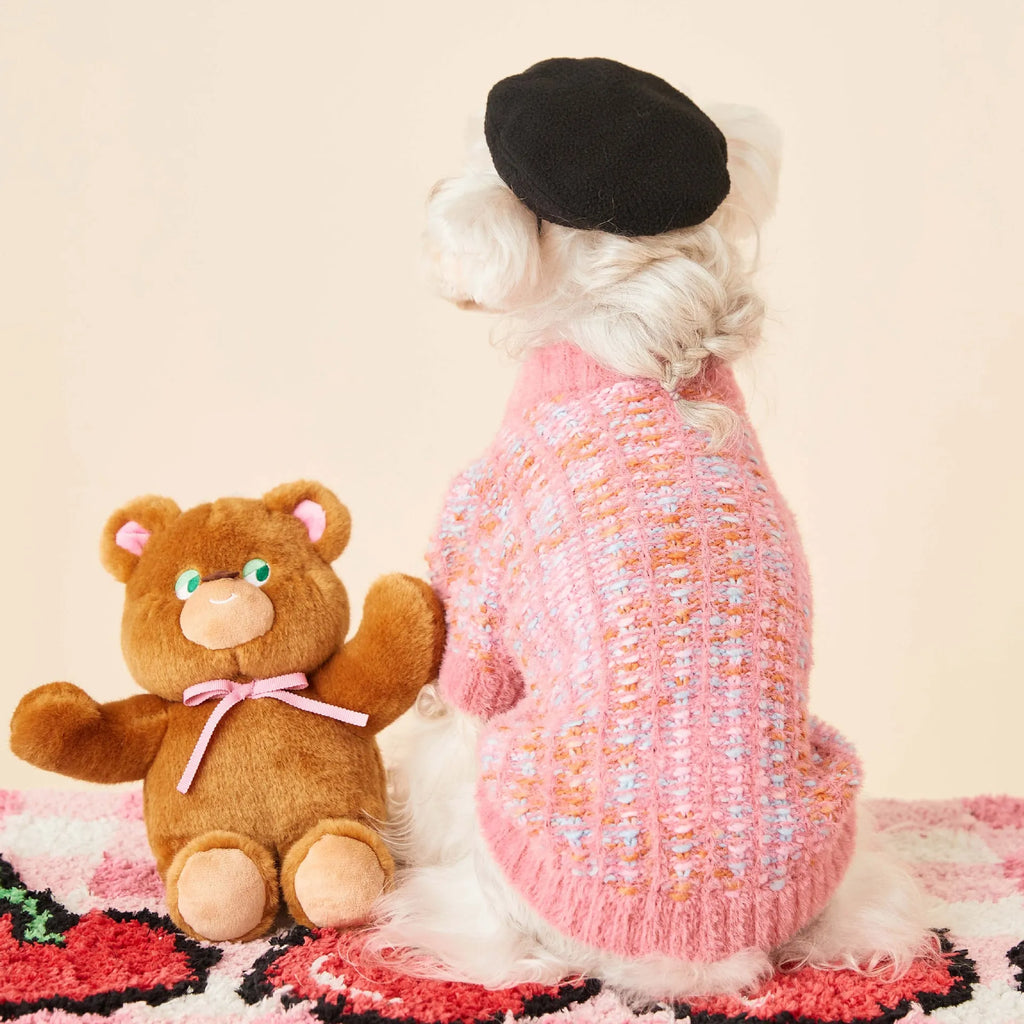 Female dog wearing a colourized wool pet cardigan in pink with a vest-style fit, side view