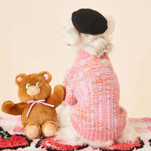 Female dog wearing a colourized wool pet cardigan in pink with a vest-style fit, side view