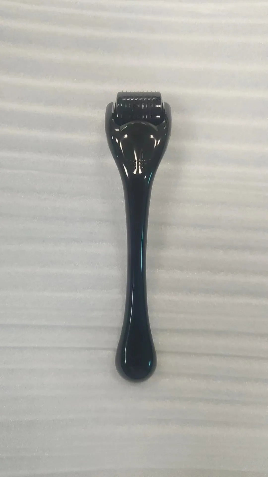 540 micro needle derma roller with black handle and purple wheel, showing adjustable needle sizes.