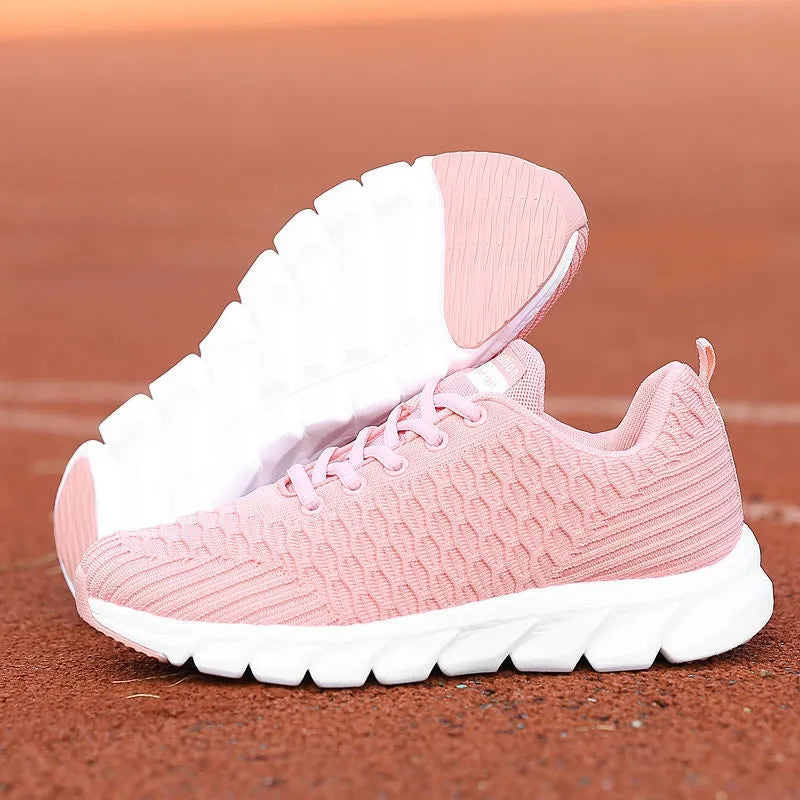 Women's running shoes in black, pink, or white with a fly-weave upper and durable outsole.