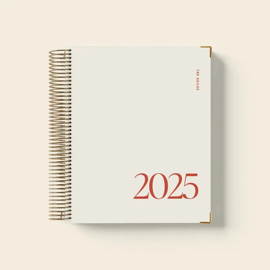 Cherry red A4 coil notebook open showing daily schedule layout with spiral binding