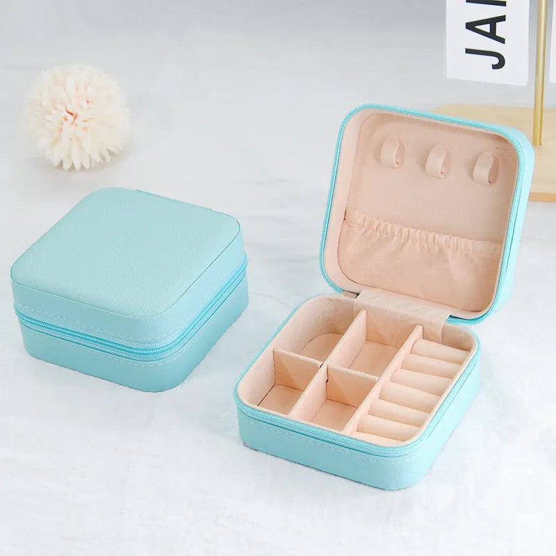 Small leather jewellery box in cross pattern, 10cm size, for earrings and rings, on a flat surface.