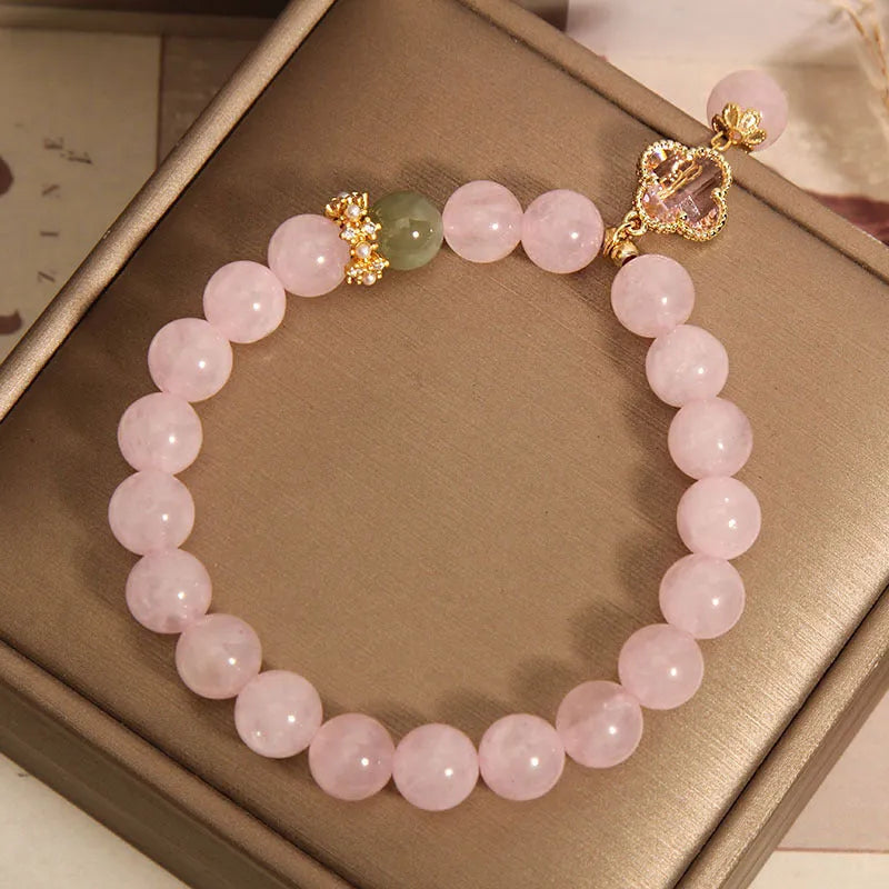Pink crystal bracelet for women with a four-leaf clover pendant and sparkling rhinestones.
