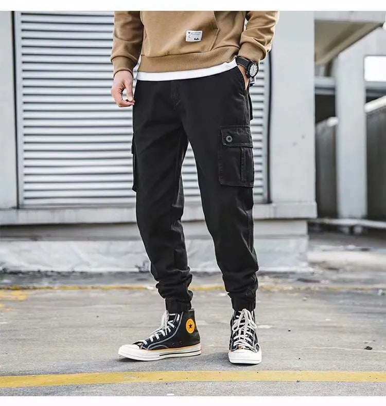Men's black cotton overalls with loose cropped fit, ankle banded hem, and multiple pockets