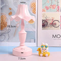 Cute cream retro table lamp with pink floral accents on a desk