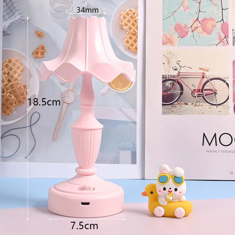 Cute cream retro table lamp with pink floral accents on a desk