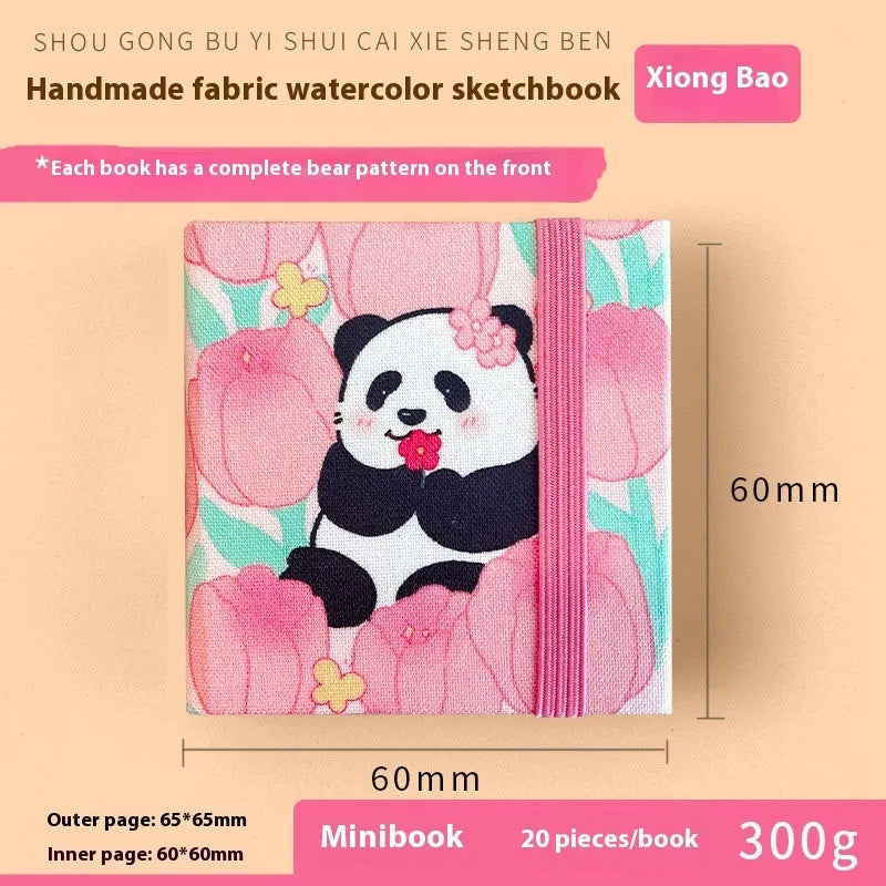 Feiluniao handmade fabric watercolour notebook with illustrated cover, open to show blank paper pages.