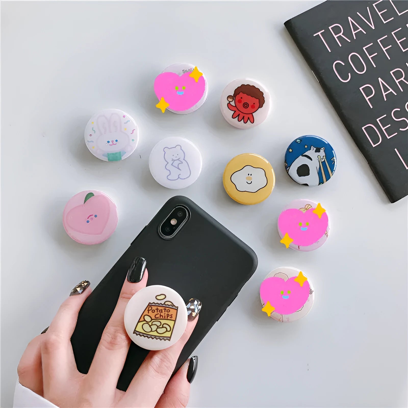 Creative telescopic glue cartoon mobile phone airbag bracket on desktop showing extended arm and cartoon colour design