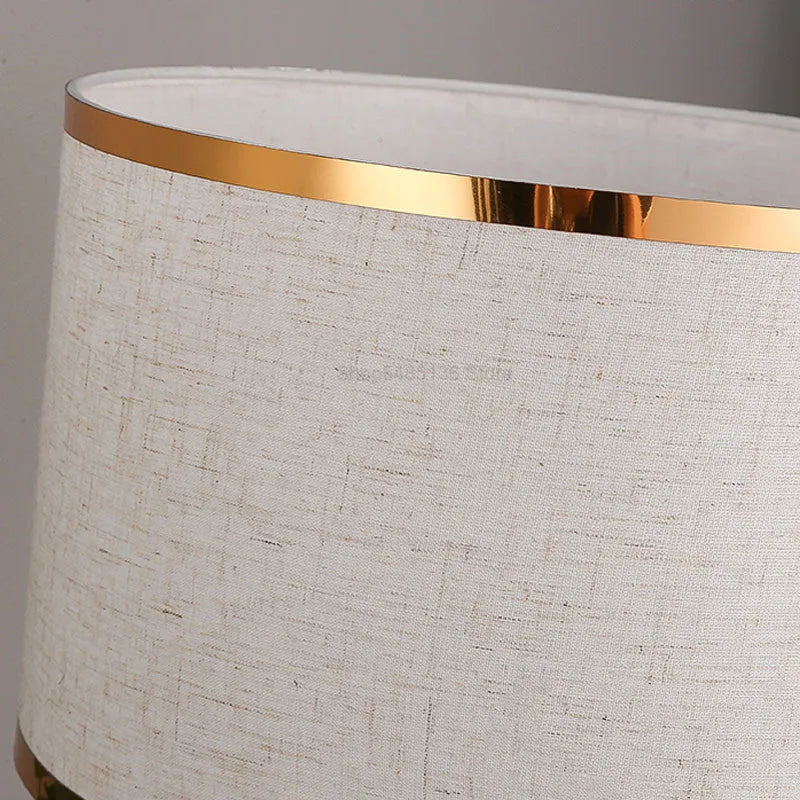 Black, gold, or white bedside table lamp with a fabric shade and iron base