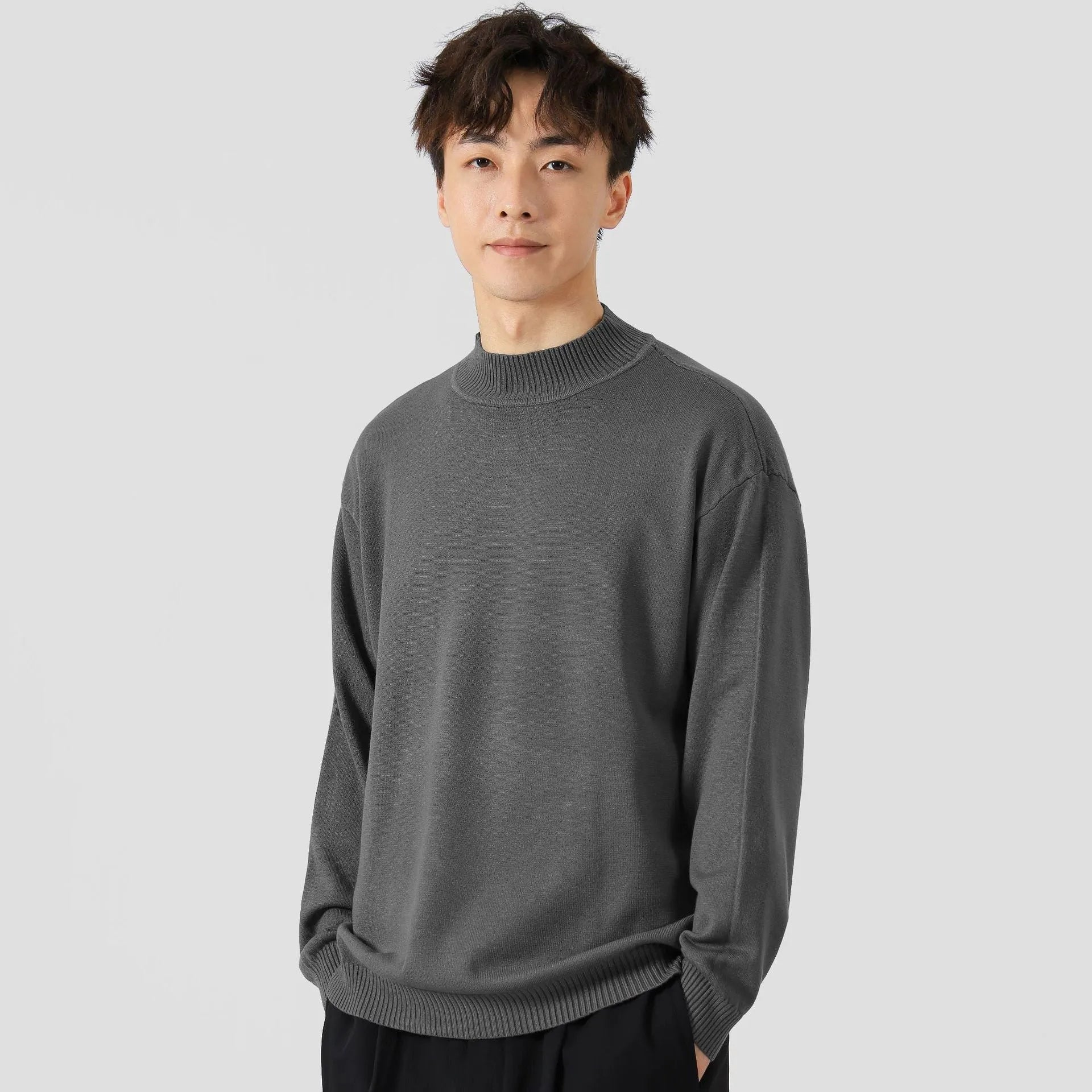 A man's loose-fitting, long-sleeve pullover sweater in a solid colour, showing a casual relaxed fit.