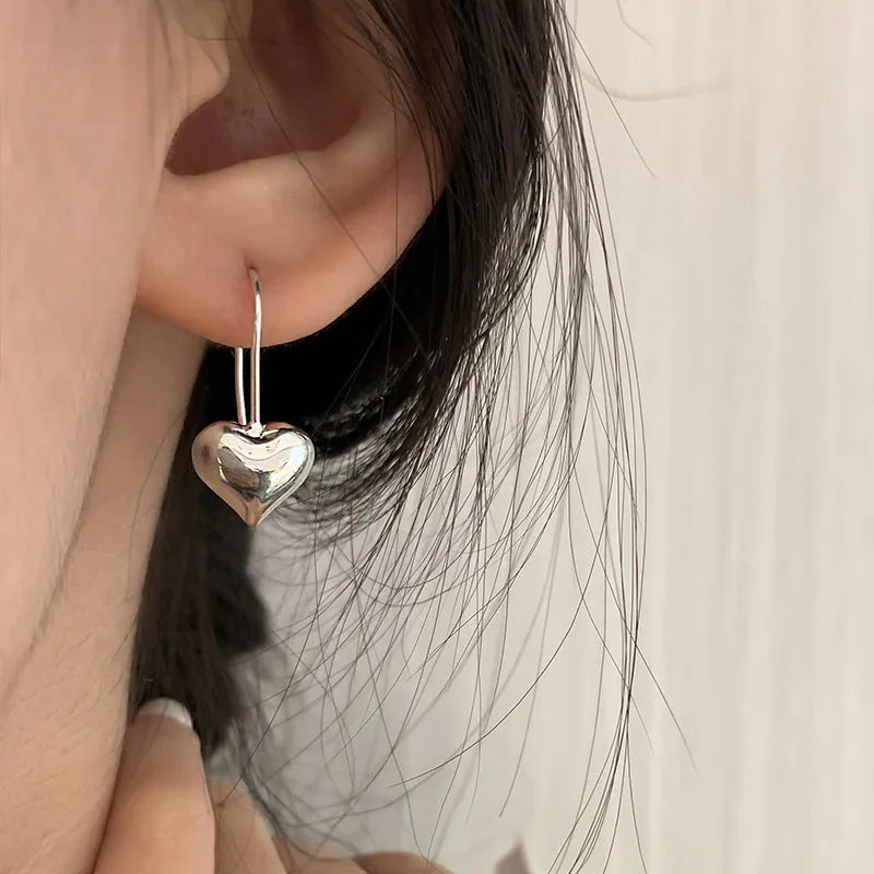 Silver heart-shaped women's earrings with glossy finish and three-dimensional design