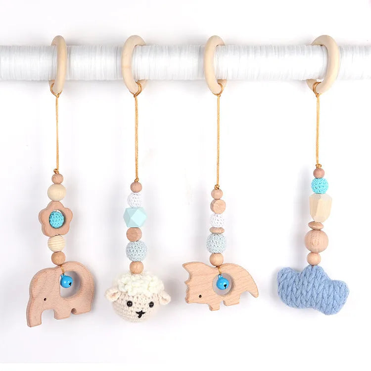 Beech wood baby rattle with animal pendants in orange, 28cm length, on white background