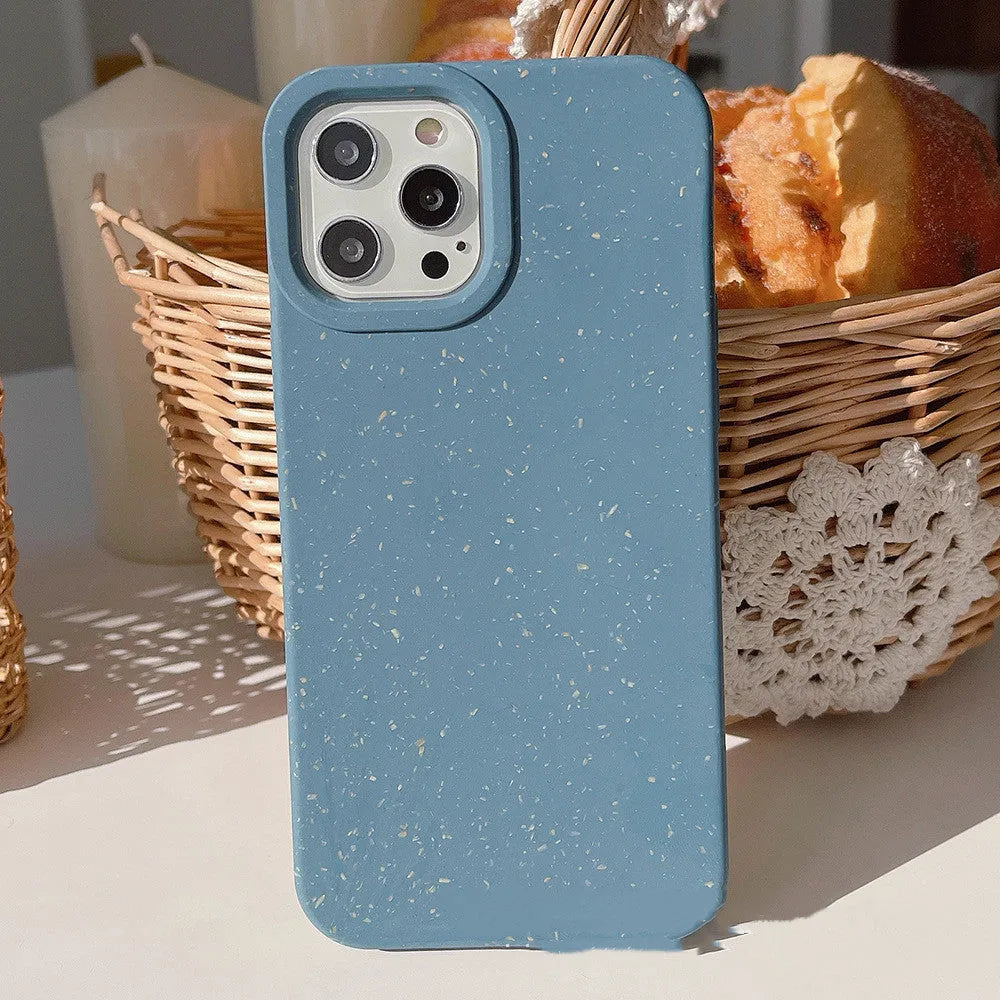 Degradable wheat straw phone case for Apple iPhone on a wooden surface.