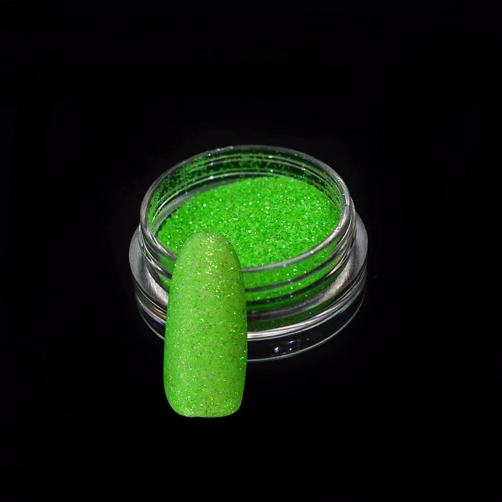 Six 1g pots of neon nail glitter powder in blue, green, orange, pink, purple, and yellow colours on a white background