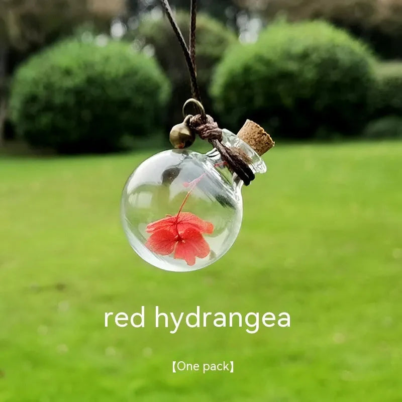 Glass car perfume pendant with preserved flower decoration hanging in car interior