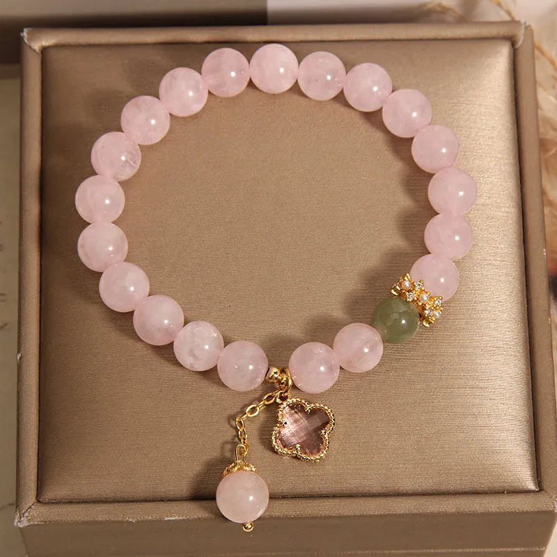 Pink crystal bracelet for women with a four-leaf clover pendant and sparkling rhinestones.