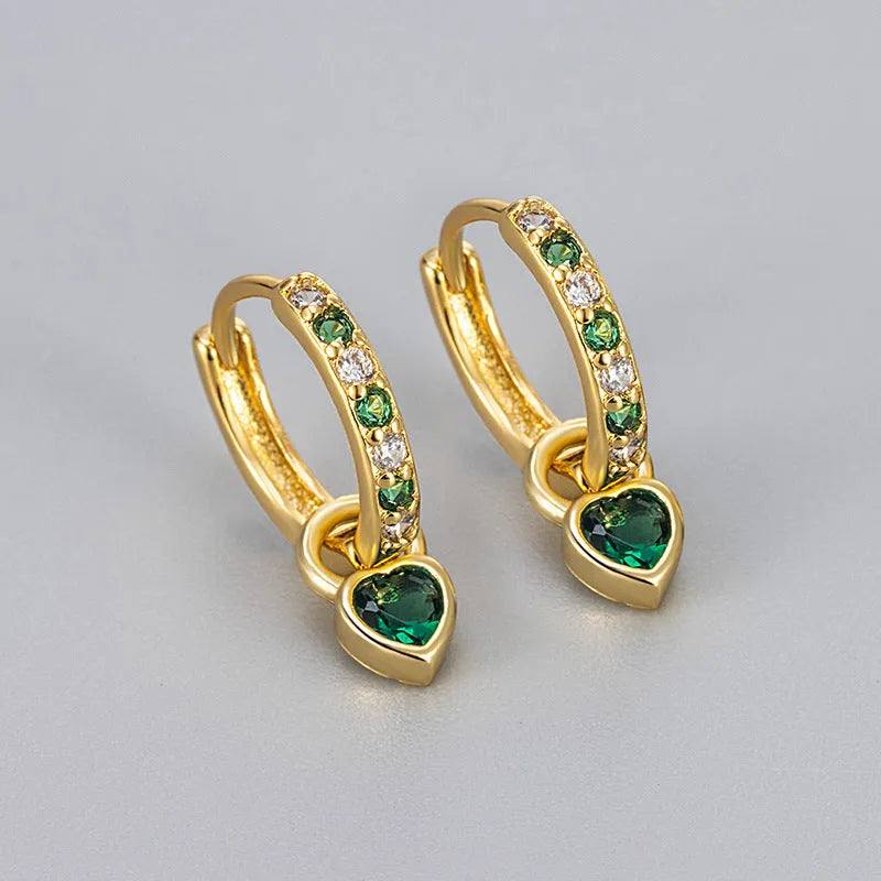 Gold colour heart-shaped clip earring with a central blue zircon stone on a white background.