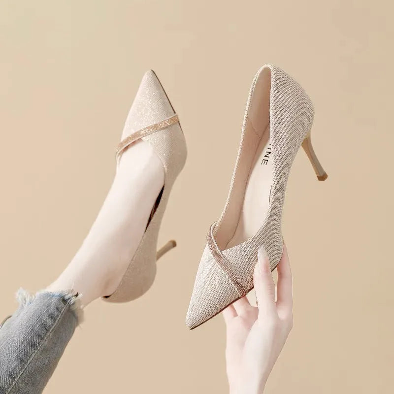 Gold women's pointed toe stiletto high heels with a low cut design on a plain background.