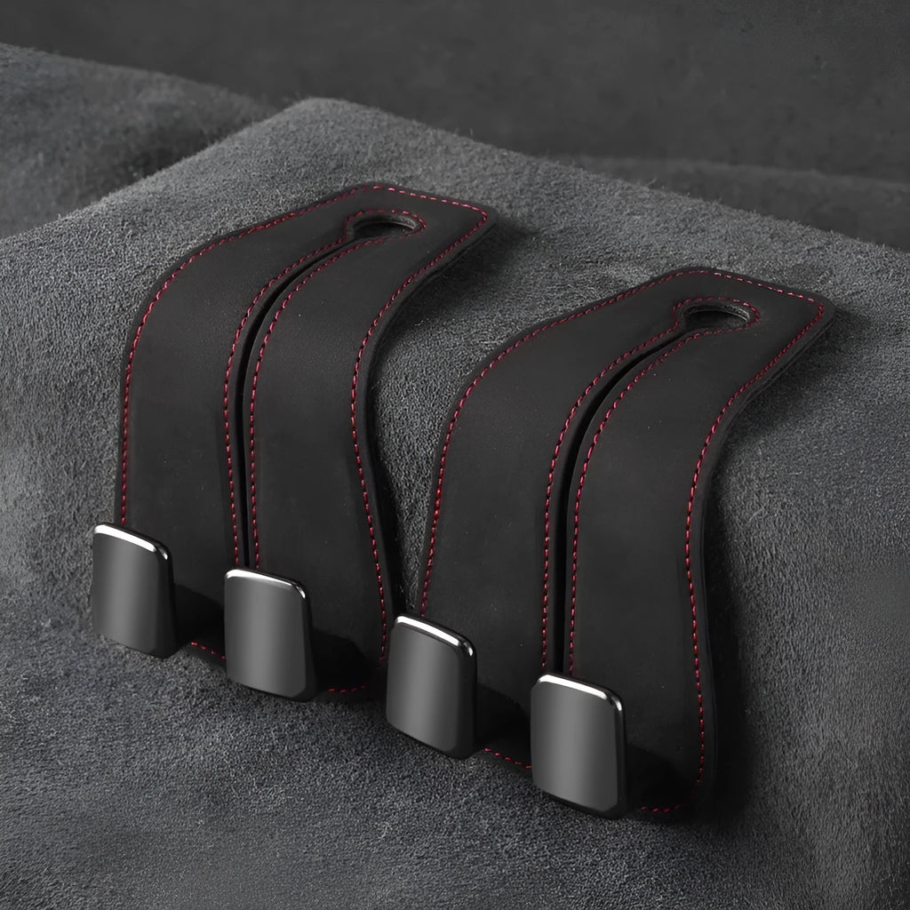 Black suede and metal car seat hook organiser hanging on a car headrest.