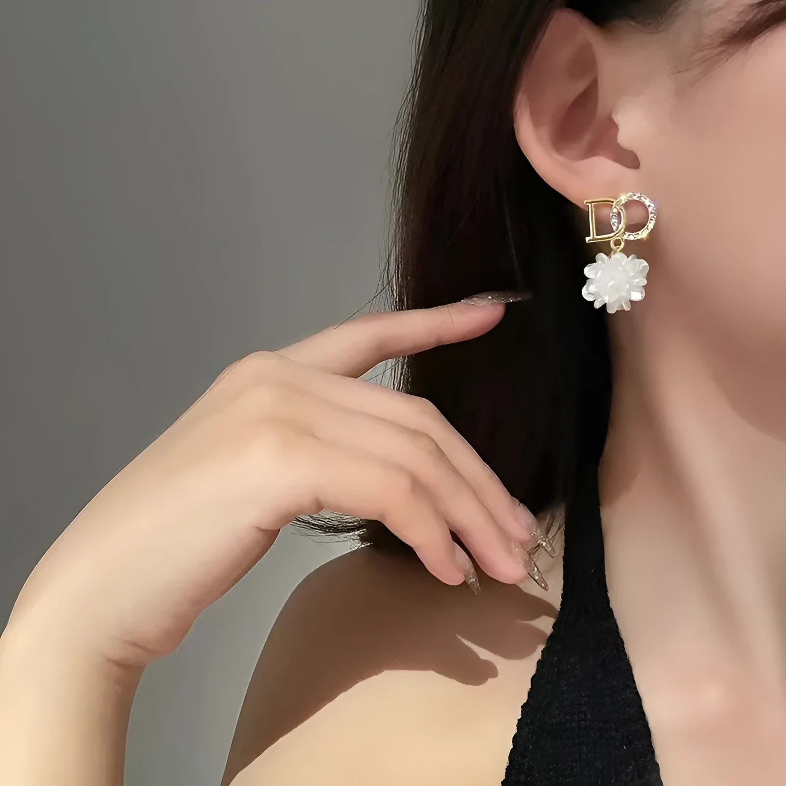 White acrylic DO letter embroidered ball stud earrings for women on light background