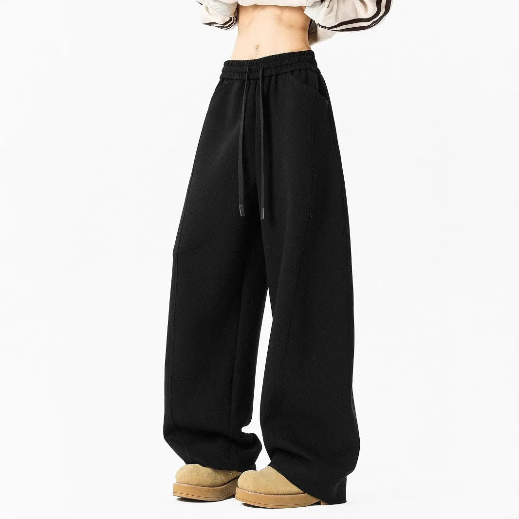 Men’s relaxed fit dark gray trousers with drawstring waist and belt on model
