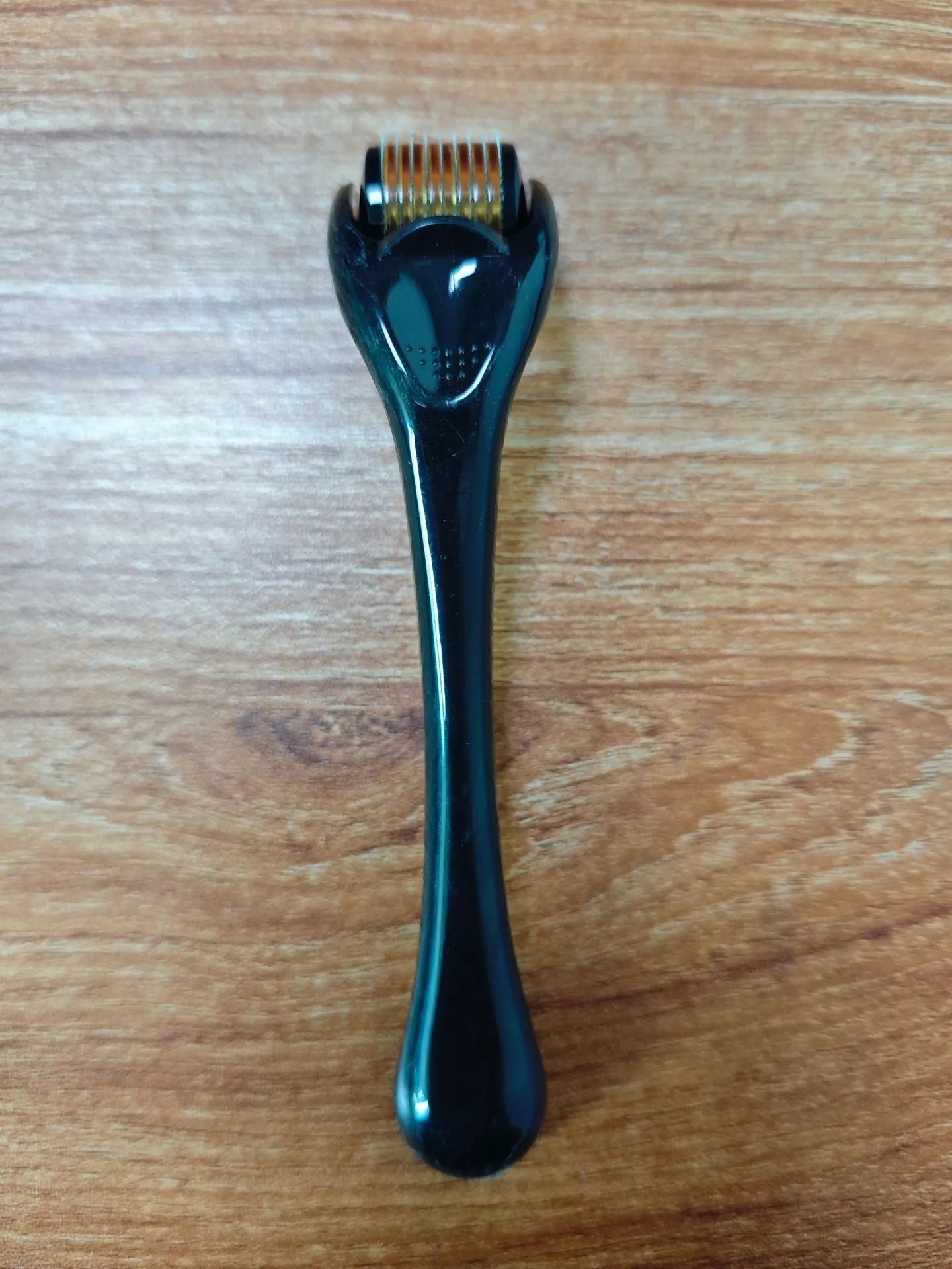540 micro needle derma roller with black handle and purple wheel, showing adjustable needle sizes.