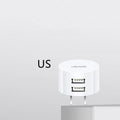 White portable universal dual USB phone charger showing US, EU and UK plug compatibility