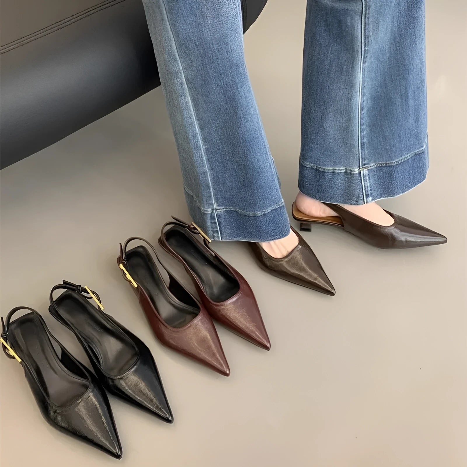 Women's black leather pointed-toe shoes with a thin low heel and an ankle strap.