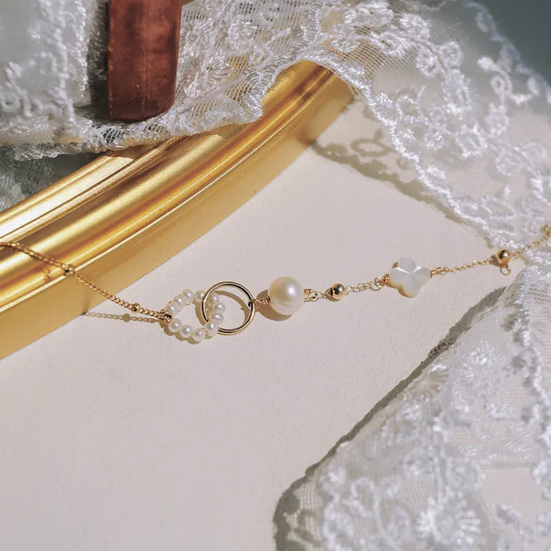 Women's adjustable natural pearl bracelet with gold-plated clasp on white background