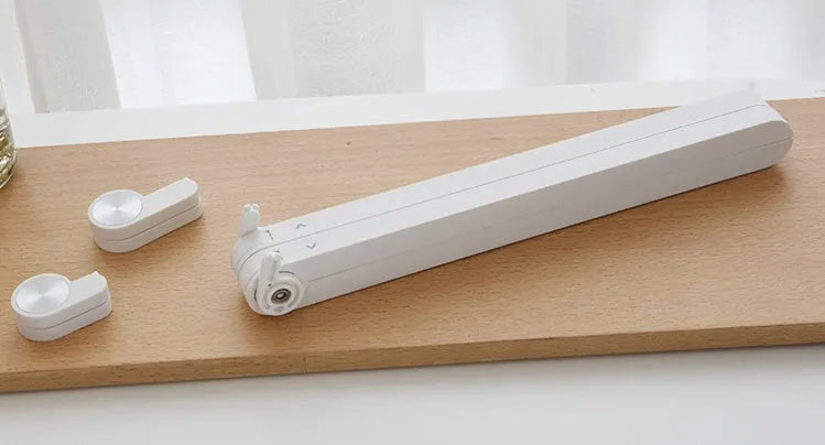 White foldable laptop stand on a desk, showing its elevated, angled position for ergonomic use.