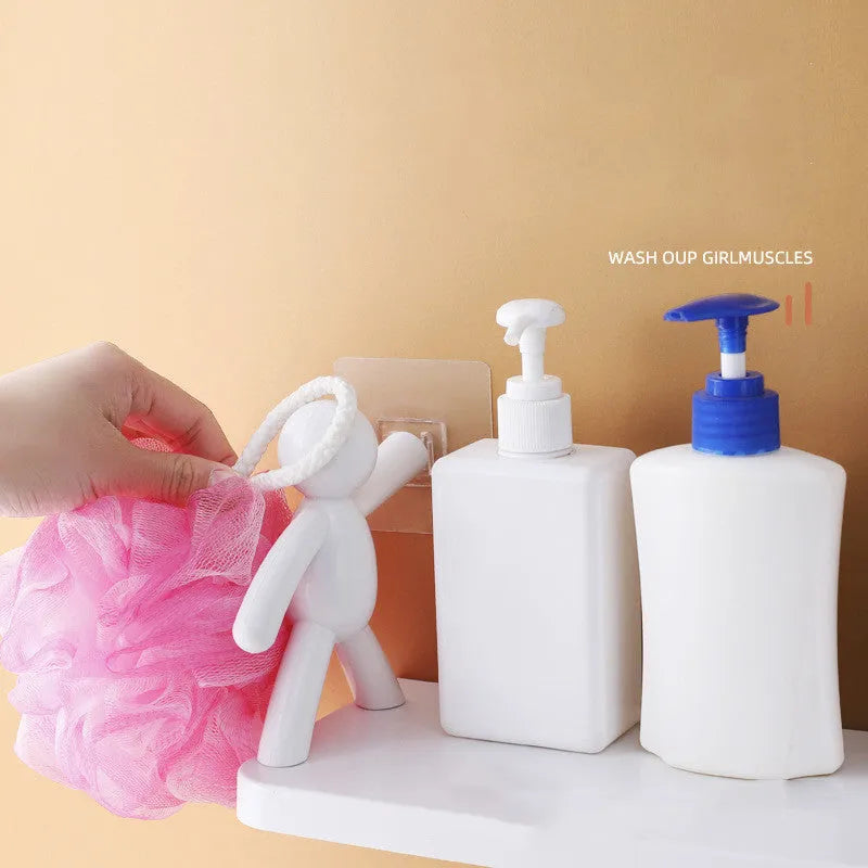 White plastic wall-mounted storage shelf in little man doll design on a bathroom wall